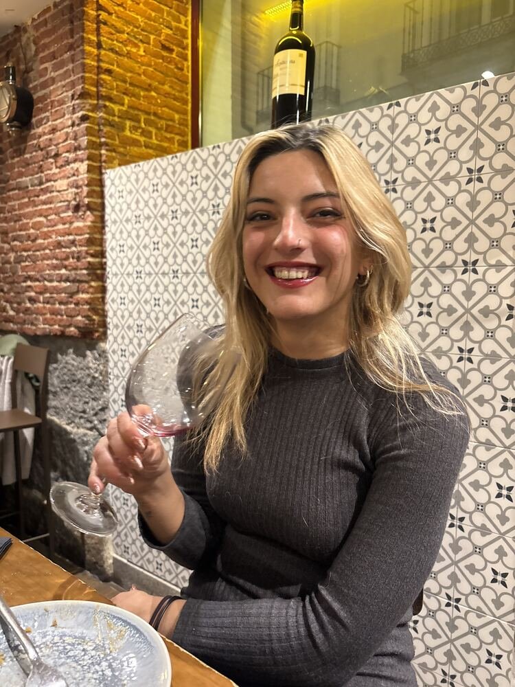 Andrea brindando con una copa de vino